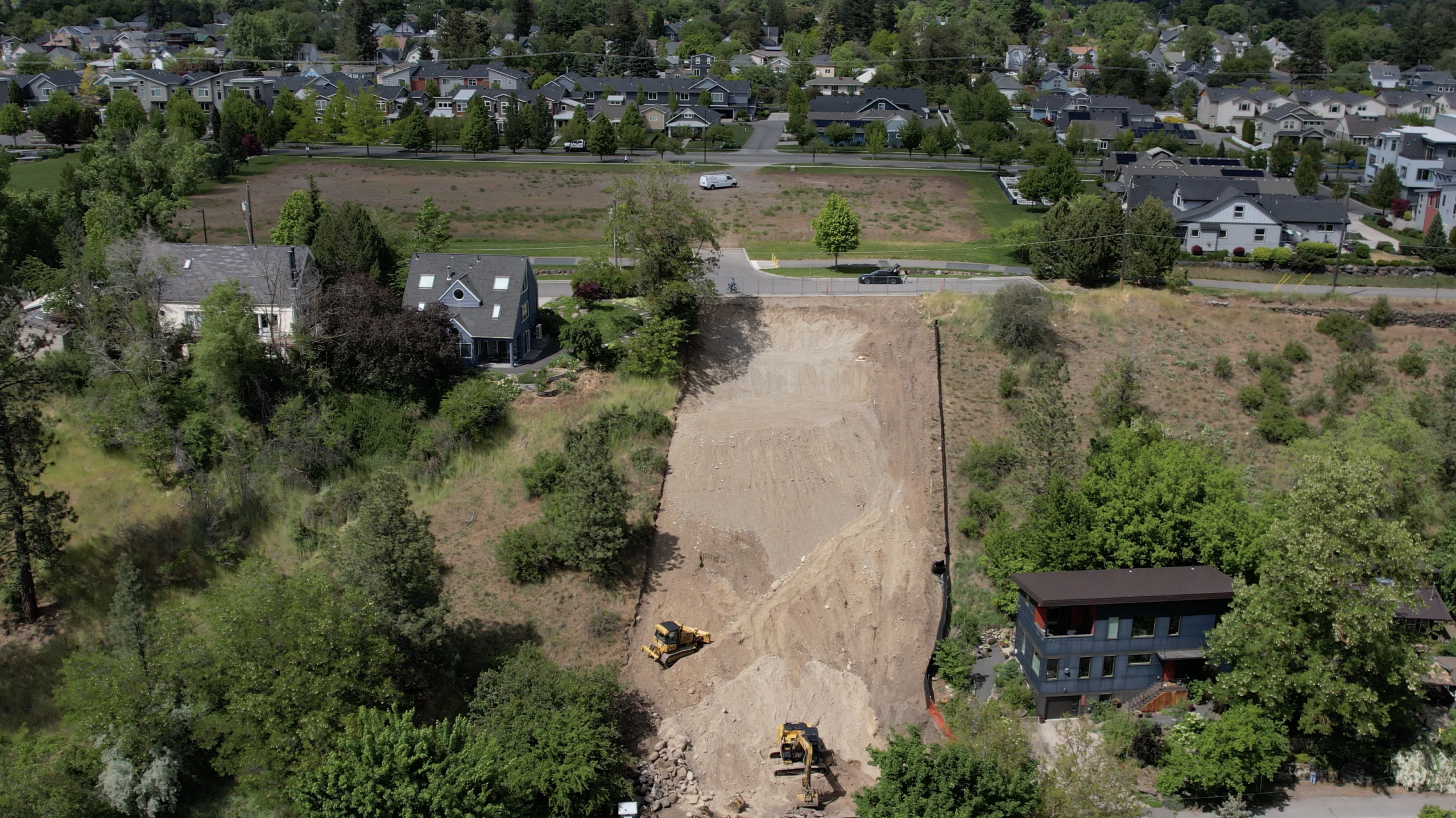 Aerial view of the site with grading progressing across the slope